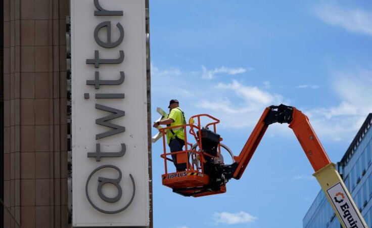 A workman removes a character from a sign on the Twitter headquarters building in San Francisco, Monday, July 24, 2023. Elon Musk has unveiled a new "X" logo to replace Twitter's famous blue bird as he follows through with a major rebranding of the social media platform he bought for $44 billion last year. The X started appearing at the top of the desktop version of Twitter on Monday, but the bird was still dominant across the smartphone app. (AP Photo/Godofredo A. Vásquez)