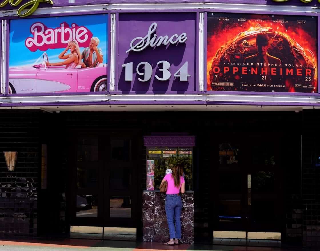 A patron buys a movie ticket underneath a marquee featuring the films "Barbie" and "Oppenheimer" at the Los Feliz Theatre, Friday, July 28, 2023, in Los Angeles. (AP Photo/Chris Pizzello). The simultaneous release resulted in the event called "Barbenheimer."