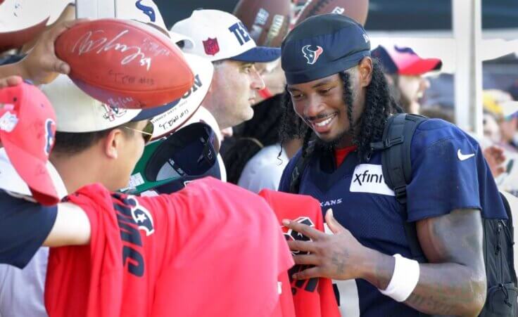 Houston Texans wide receiver John Metchie III gives autographs to fans after the NFL football team's training camp Sunday, July 30, 2023, in Houston. (AP Photo/Michael Wyke)