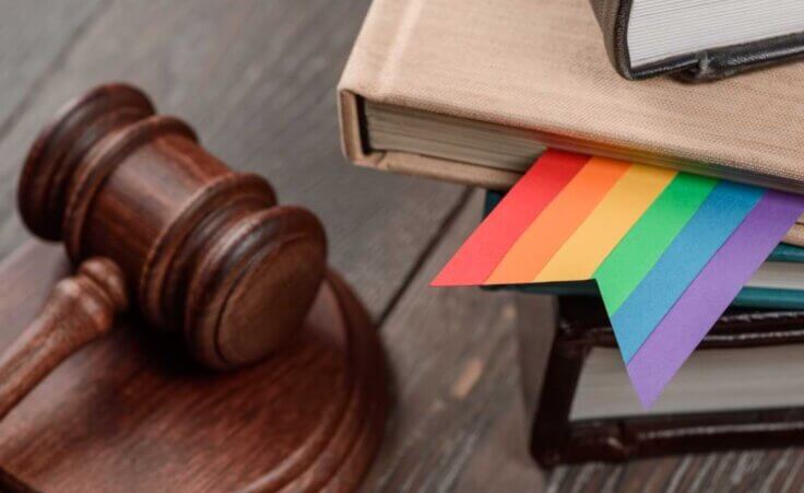 A wooden gavel sits to the left of a stack of books, one of which has a rainbow-colored bookmark within it. © By yuriygolub /stock.adobe.com. Parents from Christian, Muslim, and Jewish backgrounds in Montgomery County, Maryland, have brought a lawsuit against the district seeking to shield their children from sexual LGBTQ materials.