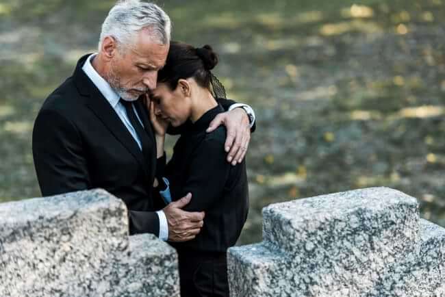 Both clad in black, a man hugs a grieving woman at a cemetery. © By LIGHTFIELD STUDIOS/stock.adobe.com. The Associated Press has reported that suicide has reached an all-time high in the US.