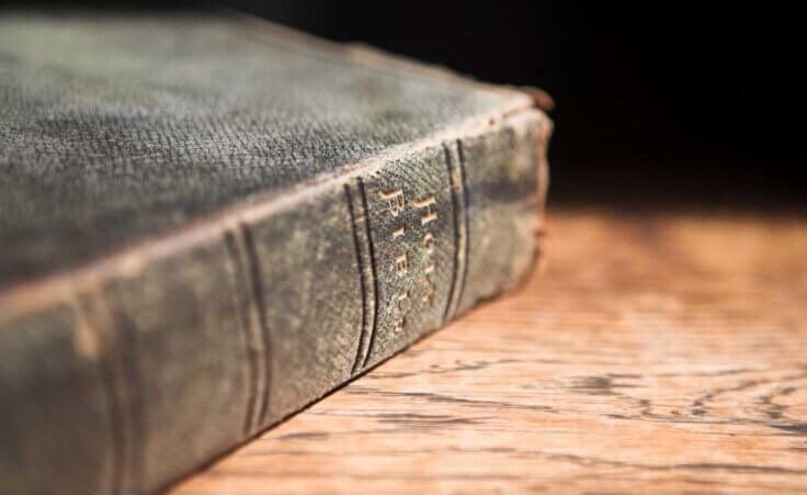 An old leather-covered Bible sits forgotten on a table, illustrating the decline in Bible reading in the US. © By Sean Nel/stock.adobe.com