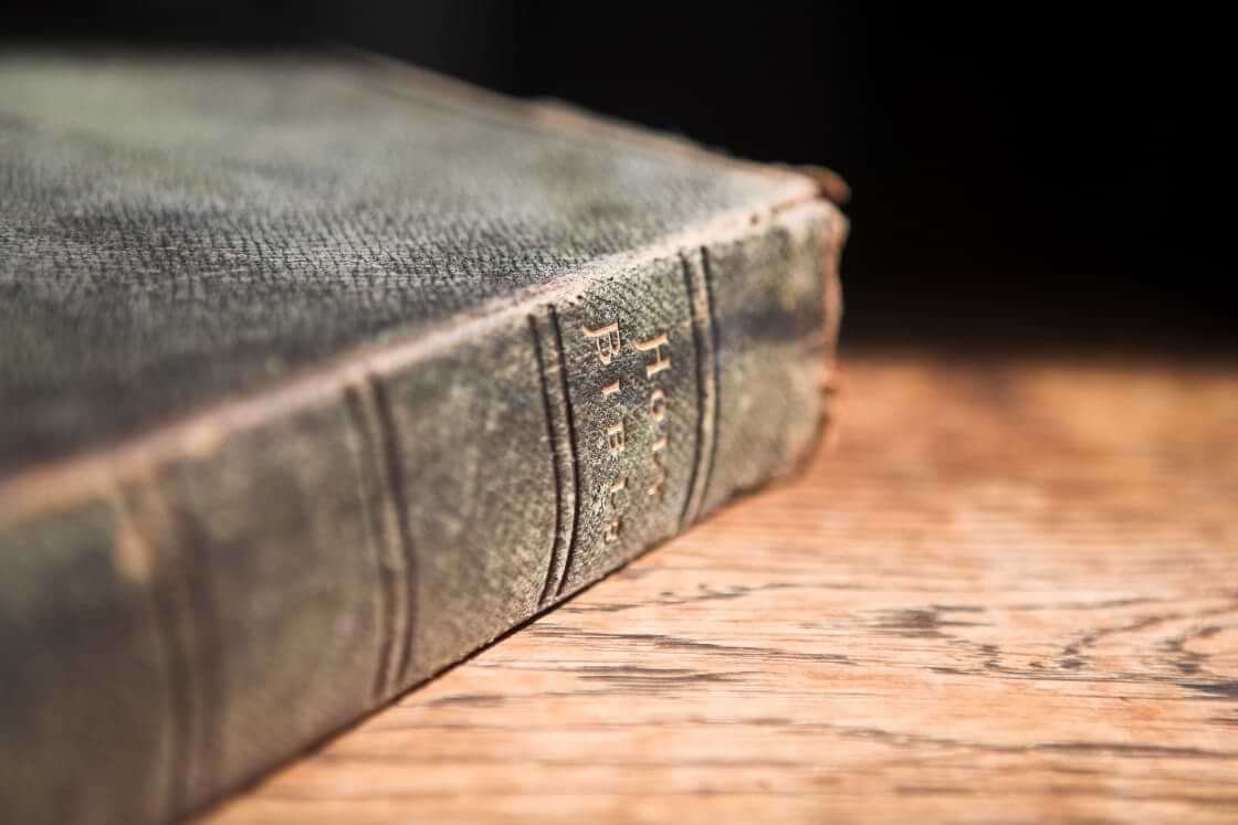 An old leather-covered Bible sits forgotten on a table, illustrating the decline in Bible reading in the US. © By Sean Nel/stock.adobe.com