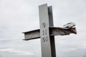 Two beams from the 9/11 attacks on the World Trade Towers form a cross. The numbers 9-11-01 are stamped on the center beam. misu /stock.adobe.com