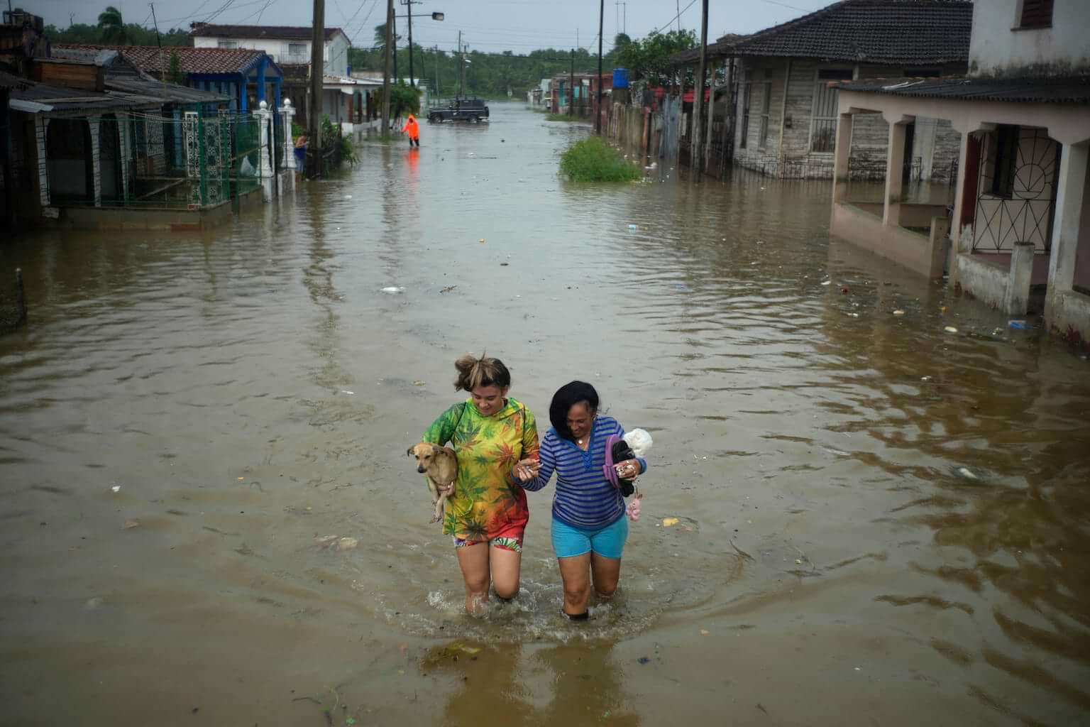 Residents wade through a street flooded by rains brought on by Hurricane Idalia, in Batabano, Cuba, Tuesday, Aug. 29, 2023. Idalia strengthened into a hurricane Tuesday and barreled toward Florida's Gulf Coast. (AP Photo/Ramon Espinosa)