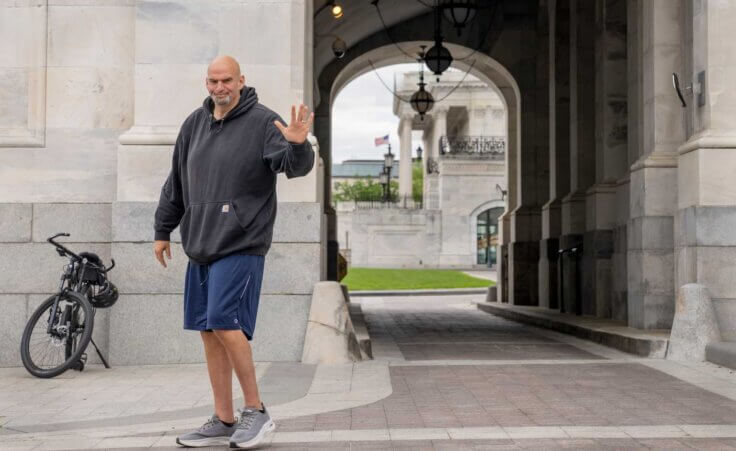 FILE - Sen. John Fetterman, D-Pa., waves to members of the media, Monday, April 17, 2023, on Capitol Hill in Washington. (AP Photo/Jacquelyn Martin, File). Amid controversy, Chuck Schumer announced a relaxation of the Senate dress code to accommodate Sen. John Fetterman's refusal to wear a suit.