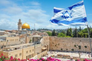 The Israel flag flies above the Western Wall in Jerusalem with the Dome of the Rock in the background. By Nick Brundle /stock.adobe.com