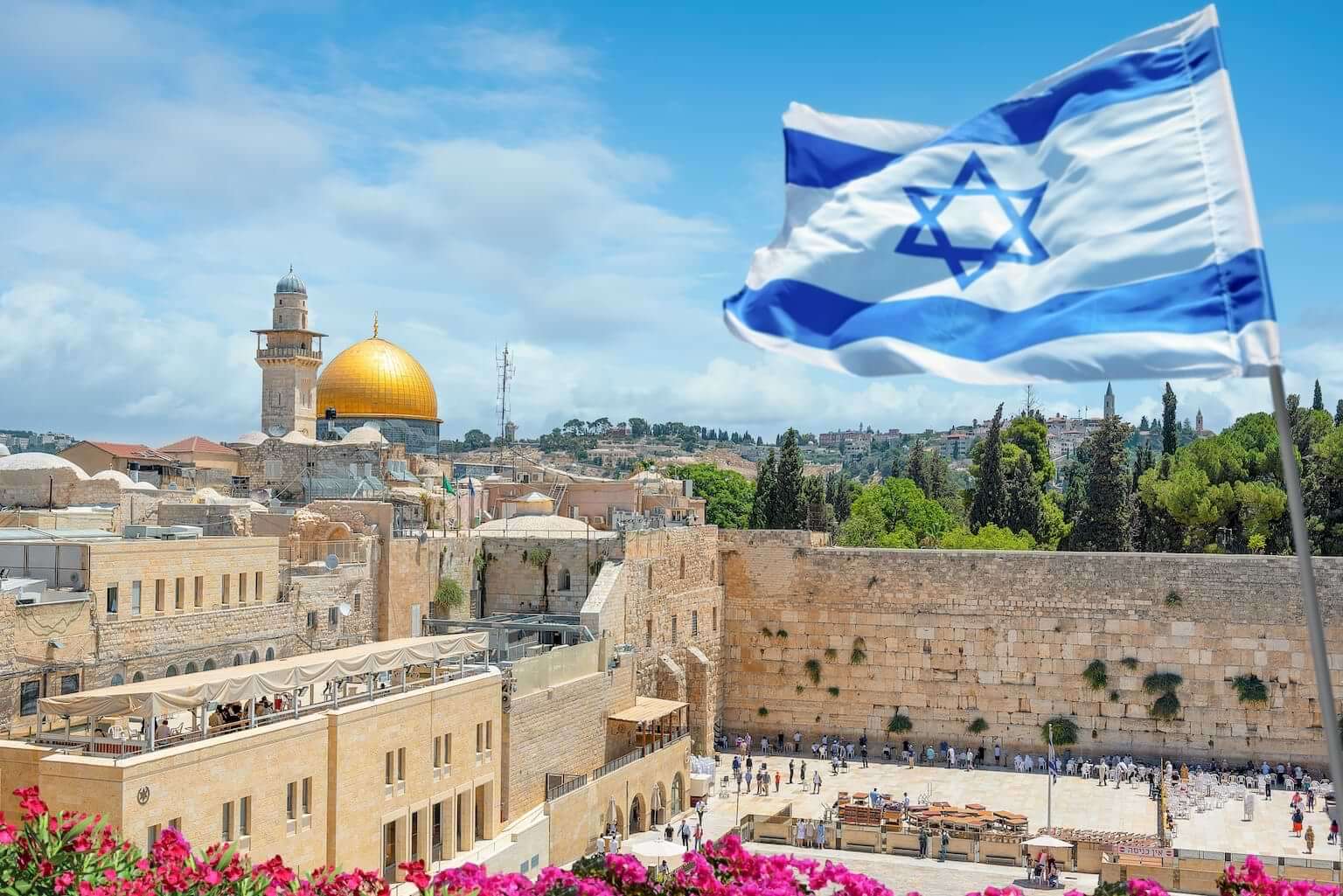 The Israel flag flies above the Western Wall in Jerusalem with the Dome of the Rock in the background. By Nick Brundle /stock.adobe.com