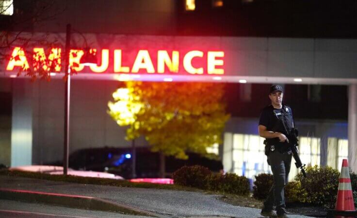 A law enforcement officer carries a rifle outside Central Maine Medical Center during an active shooter situation, in Lewiston, Maine, Wednesday, Oct. 25, 2023. (AP Photo/Steven Senne)