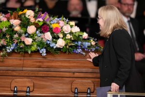 Amy Carter touches the casket after speaking at a tribute service for her mother, former first lady Rosalynn Carter, at Glenn Memorial Church at Emory University on Tuesday, Nov. 28, 2023, in Atlanta. (AP Photo/Brynn Anderson, Pool)