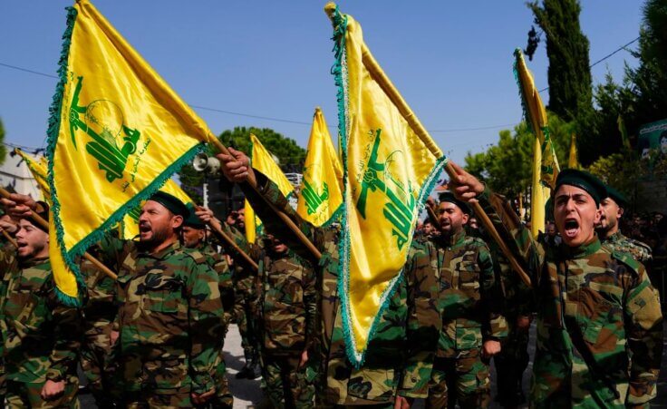 Hezbollah fighters rise their group's flag and shout slogans, as they attend the funeral procession of Hezbollah fighter, Bilal Nemr Rmeiti, who was killed by Israeli shelling, during his funeral procession in Majadel village, south Lebanon, Sunday, Oct. 22, 2023. (AP Photo/Hassan Ammar)