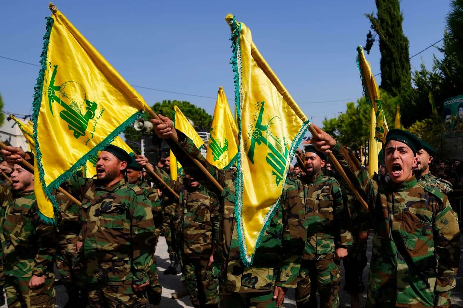 Hezbollah fighters rise their group's flag and shout slogans, as they attend the funeral procession of Hezbollah fighter, Bilal Nemr Rmeiti, who was killed by Israeli shelling, during his funeral procession in Majadel village, south Lebanon, Sunday, Oct. 22, 2023. (AP Photo/Hassan Ammar)