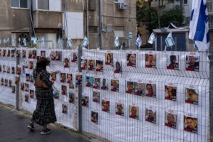 A woman looks at photographs of hostages, mostly Israeli civilians who were abducted during the Oct. 7, unprecedented Hamas attack on Israel, in Ramat Gan, Israel, Wednesday, Nov. 22, 2023. (AP Photo/Oded Balilty)