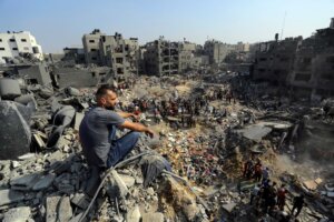 A man sits on the rubble overlooking the debris of buildings that were targeted by Israeli airstrikes in the Jabaliya refugee camp, northern Gaza Strip, Wednesday, Nov. 1, 2023. (AP Photo/Abed Khaled). As the death toll of Palestinian civilians climbs, many are calling for a ceasefire or a "humanitarian pause." But there's more to the story.