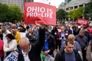 Paul Meacham holds high a sign that reads "Ohio is pro-life" as the crowd prays during the Ohio March for Life rally at the Ohio State House in Columbus, Ohio, Friday, Oct. 6, 2023. (AP Photo/Carolyn Kaster). Is the pro-life movement losing?
