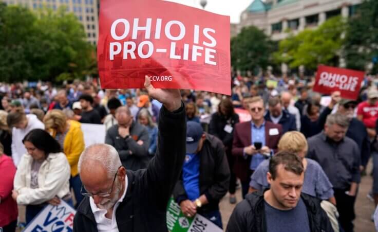 Paul Meacham holds high a sign that reads "Ohio is pro-life" as the crowd prays during the Ohio March for Life rally at the Ohio State House in Columbus, Ohio, Friday, Oct. 6, 2023. (AP Photo/Carolyn Kaster). Is the pro-life movement losing?