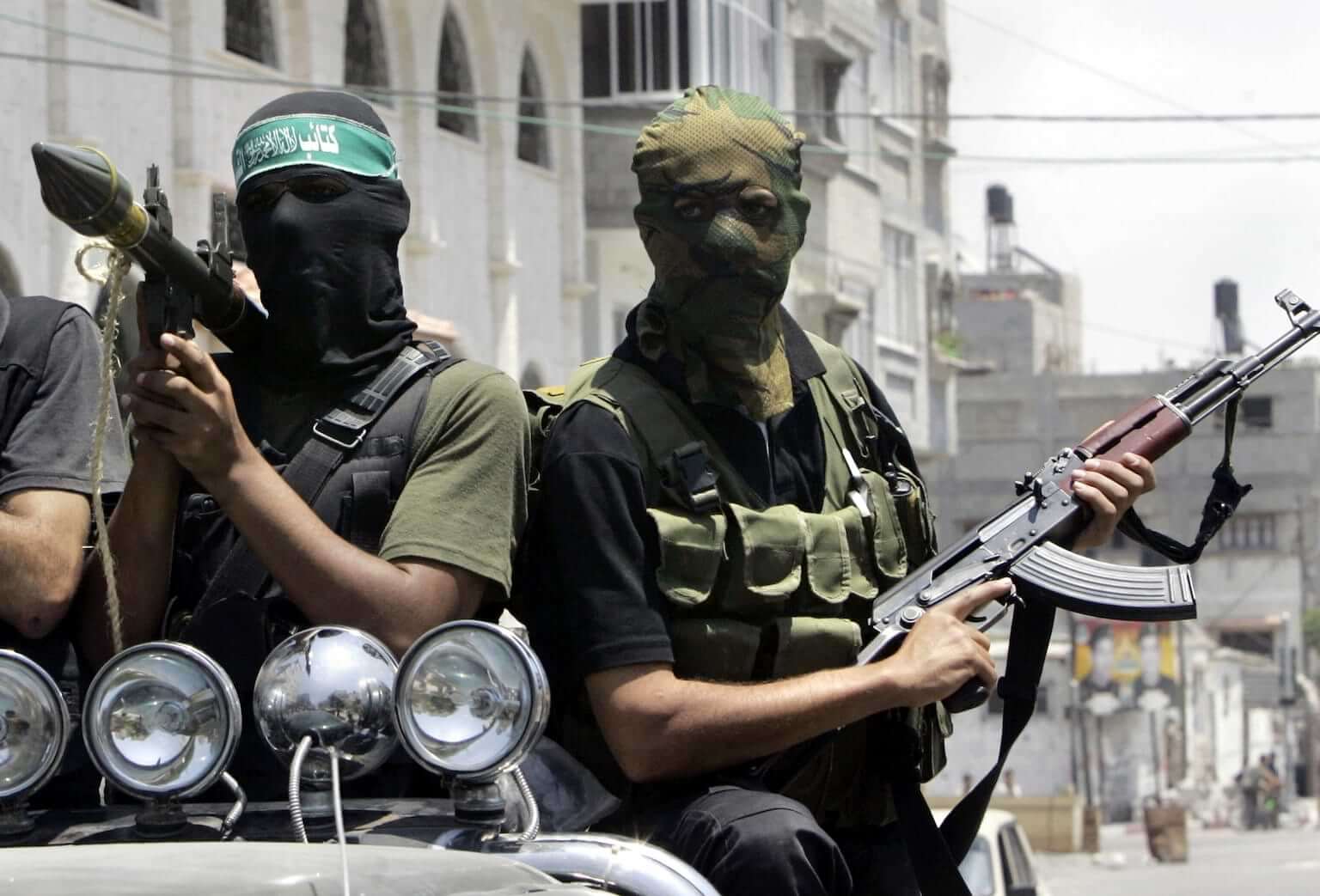 FILE - Palestinian militants from Hamas ride on a truck with their weapons during the funeral of militant Emad Abu Kados who was killed during clashes with Fatah gunmen in the Sheikh Radwan neighborhood in Gaza City, June 13, 2007. (AP Photo/Hatem Moussa, File)