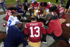 San Francisco 49ers quarterback Brock Purdy (13) kneels in prayer with teammates and Dallas Cowboys wide receiver Brandin Cooks (3) after an NFL football game in Santa Clara, Calif., Sunday, Oct. 8, 2023. (AP Photo/Godofredo A. Vásquez)