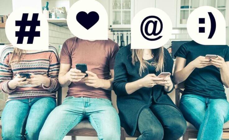 A group of four Gen Z young adults sit next to each other, each one looking at their phone, and each person's head is covered by an emoji. By rzoze19/stock.adobe.com