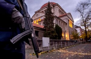 A German police officer stands guard in front of the synagogue in Frankfurt, Germany, early Wednesday, Nov. 8, 2023. Antisemitism is spiking across Europe after Hamas' Oct. 7 massacre and Israel's bombardment of Gaza, worrying Jews from London to Geneva and Berlin. (AP Photo/Michael Probst)