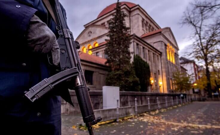 A German police officer stands guard in front of the synagogue in Frankfurt, Germany, early Wednesday, Nov. 8, 2023. Antisemitism is spiking across Europe after Hamas' Oct. 7 massacre and Israel's bombardment of Gaza, worrying Jews from London to Geneva and Berlin. (AP Photo/Michael Probst)