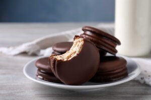 A half-eaten MoonPie sits in front of a plate of MoonPies. By New Africa/stock.adobe.com