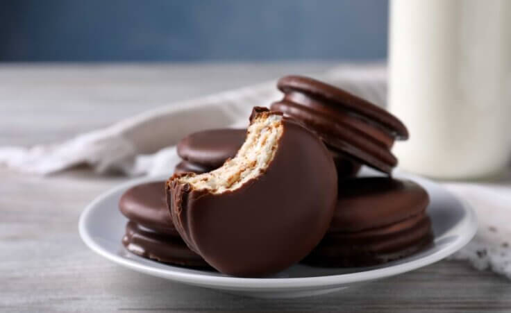 A half-eaten MoonPie sits in front of a plate of MoonPies. By New Africa/stock.adobe.com