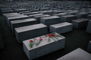 FILE - Flowers lie on a concrete slab of the Holocaust Memorial to mark the International Holocaust Remembrance Day and commemorating the 70th anniversary of the liberation of the Nazi Auschwitz death camp in Berlin, Jan. 27, 2015. (AP Photo/Markus Schreiber, File)