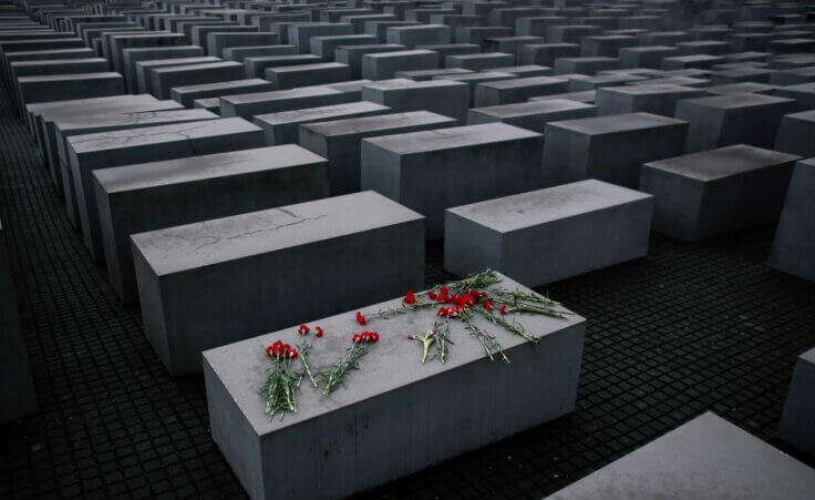 FILE - Flowers lie on a concrete slab of the Holocaust Memorial to mark the International Holocaust Remembrance Day and commemorating the 70th anniversary of the liberation of the Nazi Auschwitz death camp in Berlin, Jan. 27, 2015. (AP Photo/Markus Schreiber, File)