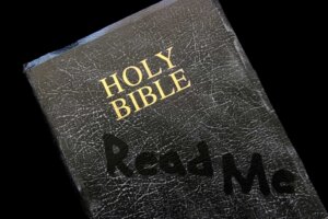 A dusty Bible has the words "Read Me" hand-drawn on its cover. By Julie Hagan/stock.adobe.com