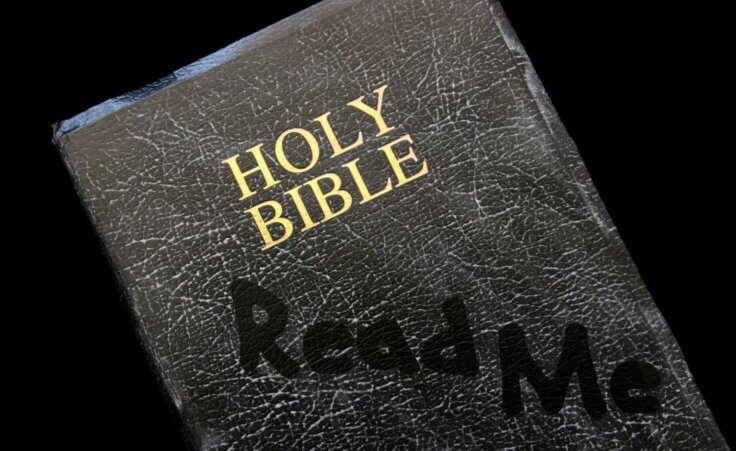 A dusty Bible has the words "Read Me" hand-drawn on its cover. By Julie Hagan/stock.adobe.com