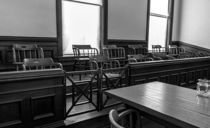 FILE - A modern juror's box in black and white featuring 12 empty chairs, representing the setting of the 1957 film "12 Angry Men." By ehrlif/stock.adobe.com