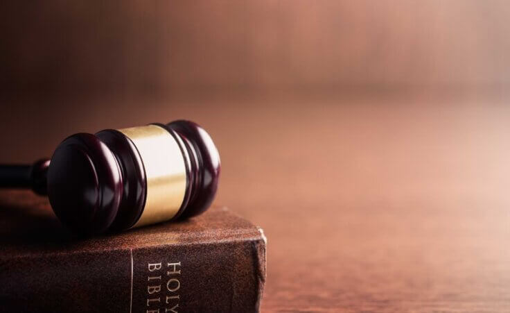 A gavel rests on top of a closed Bible. By Jiri Hera/stock.adobe.com