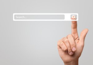 A pointer finder touches the magnifying glass on a search bar, an illustration of the pastor search process. By BillionPhotos.com /stock.adobe.com