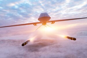 A flying drone flies toward the camera and shoots two missiles, an illustration of AI warfare. By Photocreo Bednarek/stock.adobe.com