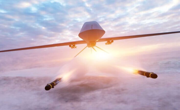 A flying drone flies toward the camera and shoots two missiles, an illustration of AI warfare. By Photocreo Bednarek/stock.adobe.com