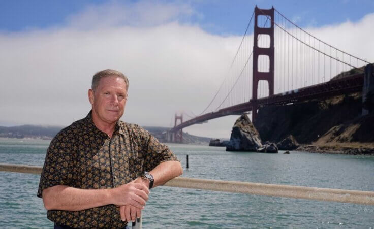 In this Aug. 3, 2021 photo retired California Highway Patrol officer Kevin Briggs poses below the Golden Gate Bridge near Sausalito, Calif. Briggs responded to many suicide attempts on the Golden Gate Bridge during his career. He met Kevin Berthia in 2005 when Berthia attempted suicide and now the two speak nationally about suicide prevention. Briggs joined the CHP in 1990 and began responding to emergencies on the bridge in 1994, where he would work with people in crisis four to six times a month. He retired in 2013. (AP Photo/Eric Risberg)