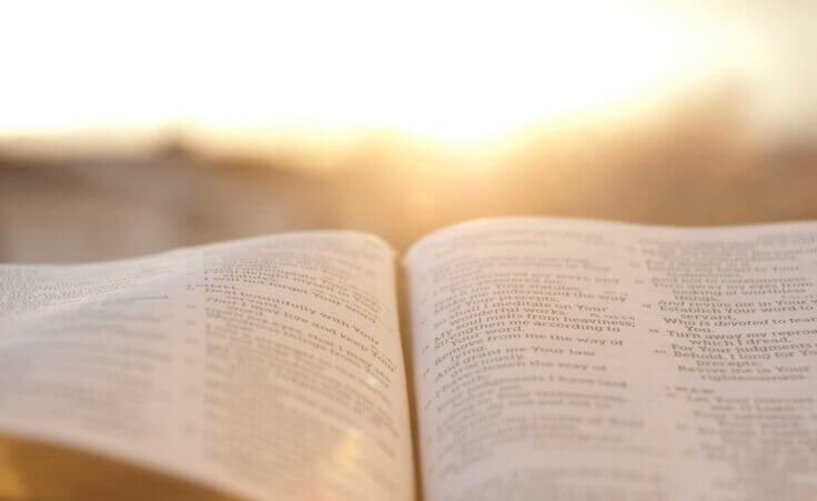 A Bible lays open in front of a sunrise. By Sergio Yoneda/stock.adobe.com