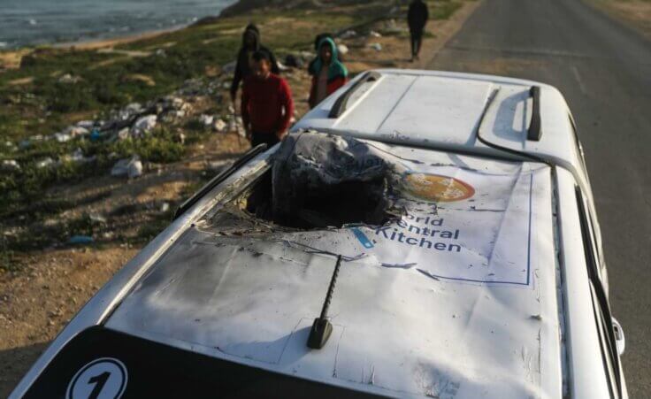 Palestinians inspect a vehicle with the logo of the World Central Kitchen wrecked by an Israeli airstrike in Deir al Balah, Gaza Strip, Tuesday, April 2, 2024. (AP Photo/Ismael Abu Dayyah)