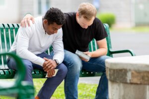 Two men praying together. By Lydia/stock.adobe.com