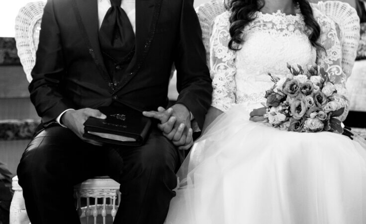 Bride and a groom holding hands during marriage ceremony. By Vlad Negru/Wirestock/Stock.Adobe.com