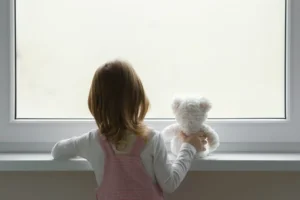 Little girl holding white teddy bear and standing alone at window. By fotoduets/stock.adobe.com Mass shooting Arkansas Callie Weems
