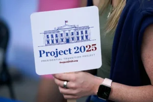 Kristen Eichamer holds a Project 2025 fan in the group's tent at the Iowa State Fair, Aug. 14, 2023, in Des Moines, Iowa. With more than a year to go before the 2024 election, a constellation of conservative organizations is preparing for a possible second White House term for Donald Trump. The Project 2025 effort is being led by the Heritage Foundation think tank. (AP Photo/Charlie Neibergall)