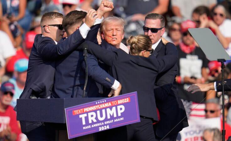 Republican presidential candidate former President Donald Trump is helped off the stage at a campaign event in Butler, Pa., on Saturday, July 13, 2024. (AP Photo/Gene J. Puskar)