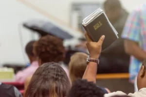 Man at church with a bible raised during church service. By Fitz/stock.adobe.com