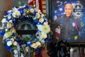 A wreath and a portrait of Dallas police officer Darron Burks are seen before funeral services at Watermark Community Church on Saturday, Sept. 7, 2024, in Dallas. (Smiley N. Pool/The Dallas Morning News via AP, Pool)
