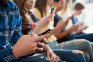 Close up of a line of high school students using mobile phones. By Monkey Business/stock.adobe.com