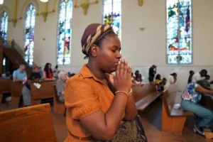 Marie Morette, a congregant of St Raphael Catholic church, prays during Mass in Springfield, Ohio, Sunday, Sept. 15, 2024. (AP Photo/Jessie Wardarski) Haitian immigrant
