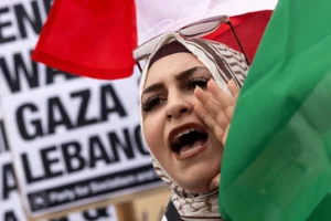 Israel and Hezbollah. A protester waves a Lebanese flag as demonstrators gather to protest against the war on Gaza and Israeli military strikes on Lebanon in front of the Los Angeles Federal Building on Tuesday, Sept. 24, 2024, in Los Angeles. (AP Photo/Etienne Laurent)
