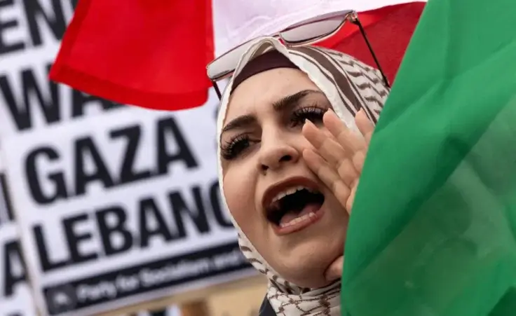 Israel and Hezbollah. A protester waves a Lebanese flag as demonstrators gather to protest against the war on Gaza and Israeli military strikes on Lebanon in front of the Los Angeles Federal Building on Tuesday, Sept. 24, 2024, in Los Angeles. (AP Photo/Etienne Laurent)